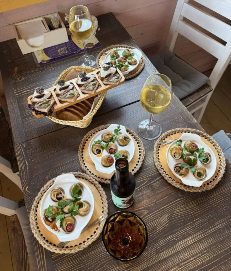 Блюдо из улитки с листочком рукколы